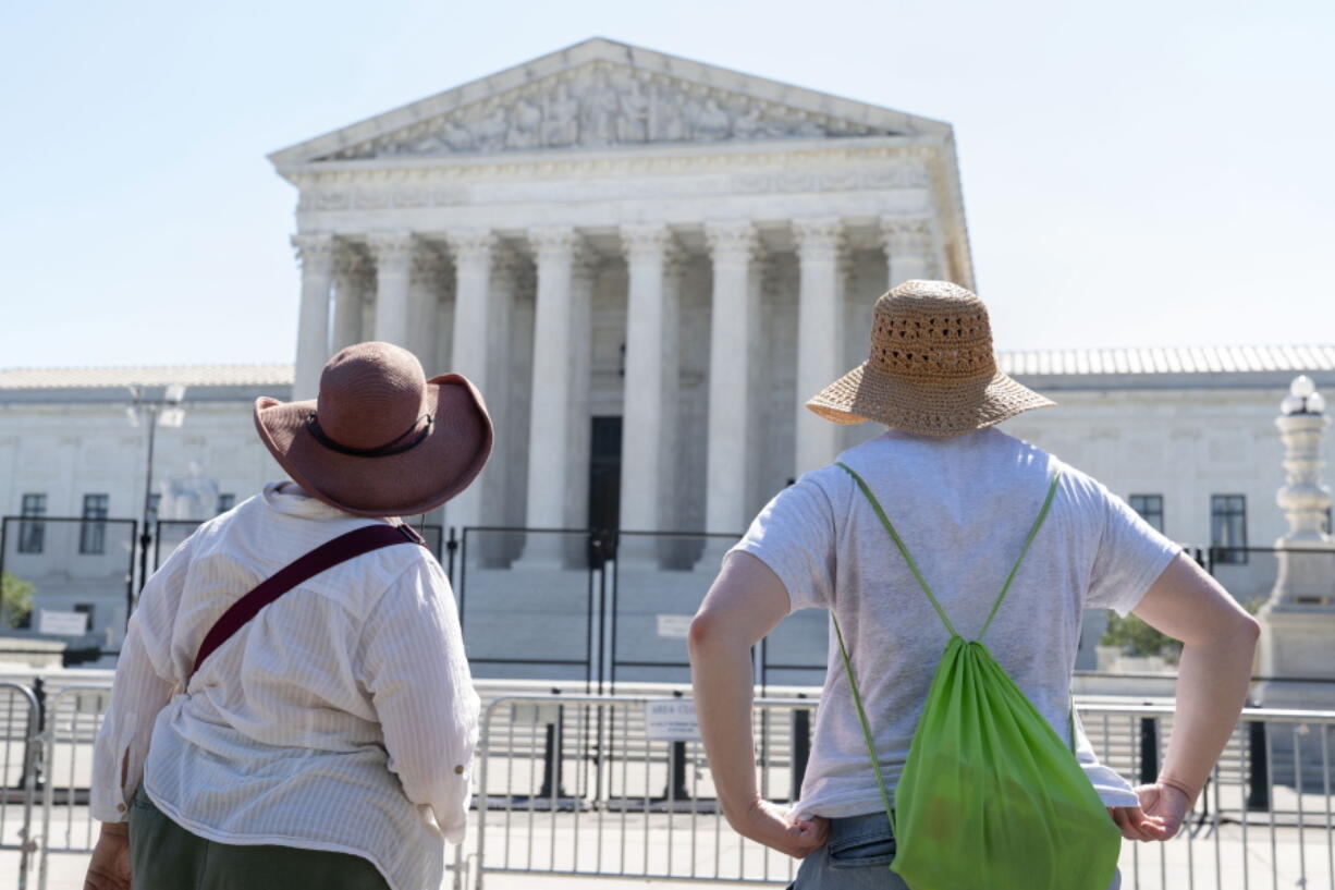 Women in sunhats look at the Supreme Court, Thursday, June 30, 2022, in Washington.