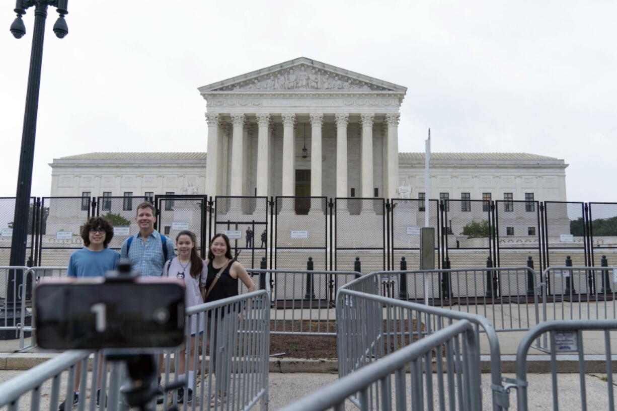A family takes a selfie outside of the U.S. Supreme Court on Capitol Hill in Washington, Thursday, June 23, 2022.