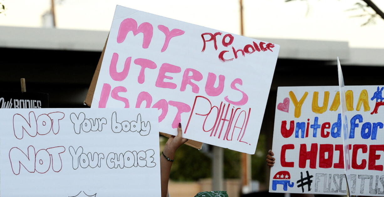 Abortion-rights activists march with signs carrying various messages during a demonstration from Heritage Library to Yuma City Hall, Wednesday, June 29, 2022, in Yuma, Ariz.
