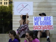 FILE - Demonstrators gather at the federal courthouse following the Supreme Court's decision to overturn Roe v. Wade, June 24, 2022, in Austin, Texas. Some opponents of the decision are feeling despair over the historic rollback of the 1973 case Roe V. Wade legalizing abortion. If a right so central to the overall fight for women's equality can be revoked, they ask, what does it mean for the progress women have made in public life in the intervening 50 years?
