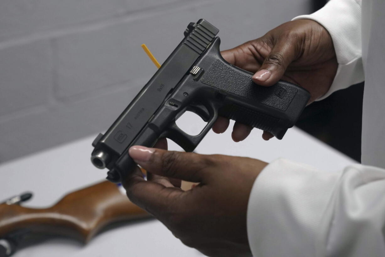 FILE - A handgun from a collection of illegal guns is reviewed during a gun buyback event in Brooklyn, N.Y., May 22, 2021. The Supreme Court, Thursday, June 23, 2022, struck down a restrictive New York gun law in a major ruling for gun rights.