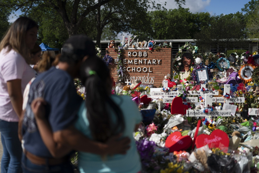 FILE - People visit a memorial at Robb Elementary School in Uvalde, Texas, on June 2, 2022, to pay their respects to the victims killed in a school shooting. A legislative committee investigating the deadly shooting at the Texas elementary school is set to hear more testimony from law enforcement officers on Monday, June 20, 2022. (AP Photo/Jae C.