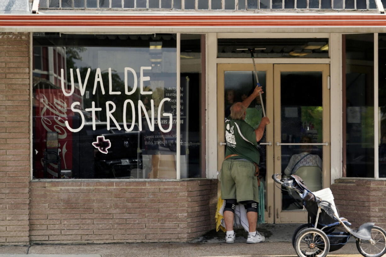 A window washer work around the town square, Thursday, June 9, 2022, in Uvalde, Texas. Uvalde is home to the Texas elementary school where a gunman killed 19 children and two teachers has long been a part of the fabric of the small city of Uvalde, a school attended by generations of families, and where the spark came that led to Hispanic parents and students to band together to fight discrimination over a half-century ago.