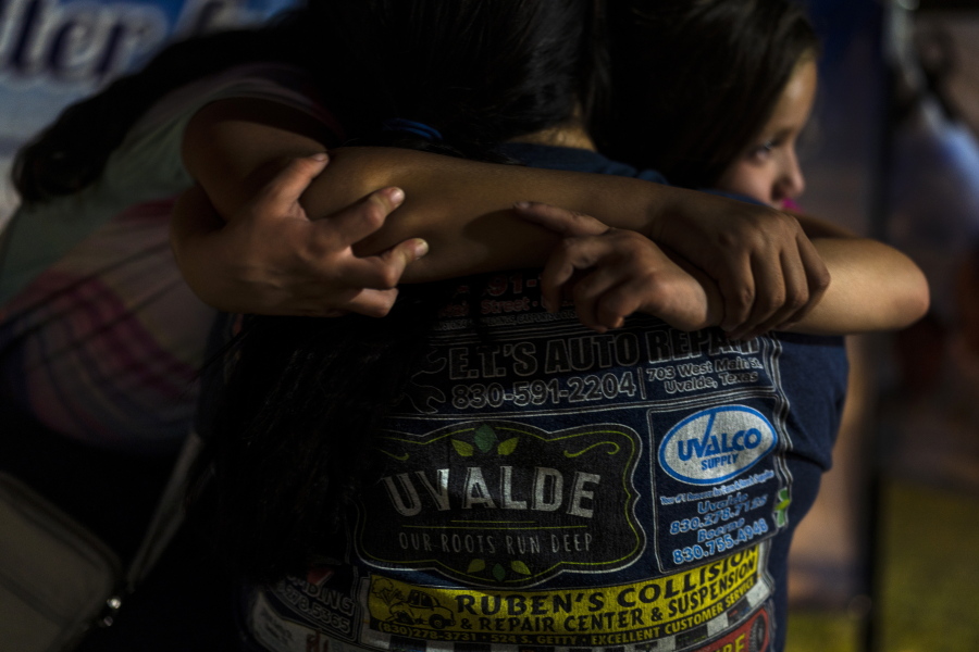 A mother and her two daughters embrace one another while visiting a memorial at a town square in Uvalde, Texas, Tuesday, May 31, 2022, to pay their respects to the victims killed in last week's elementary school shooting. (AP Photo/Jae C.