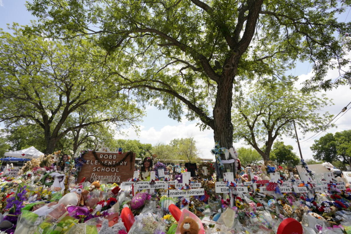 Pecan trees, planted in the 1960's, shade a memorial created to honor the victims killed in the recent school shooting at Robb Elementary, Thursday, June 9, 2022, in Uvalde, Texas. The Texas elementary school where a gunman killed 19 children and two teachers has long been a part of the fabric of the small city of Uvalde, a school attended by generations of families, and where the spark came that led to Hispanic parents and students to band together to fight discrimination over a half-century ago.