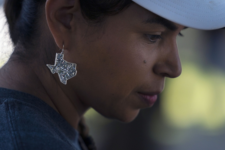 Ana Hernandez, a kindergarten teacher visiting from Dilley, Texas, wears an earring in the shape of Texas to show her support for the community while visiting a memorial in Uvalde, Texas, Friday, June 3, 2022. "Changes have to be done for us to feel secure in a classroom as a teacher (and) for students also to feel secure and safe in a classroom," said Hernandez. (AP Photo/Jae C.