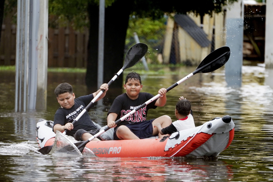 Young boys paddle an inflatable kayak on a flooded Miami street, Saturday, June 4, 2022. A tropical storm warning was in effect along portions of coastal Florida and the northwestern Bahamas.