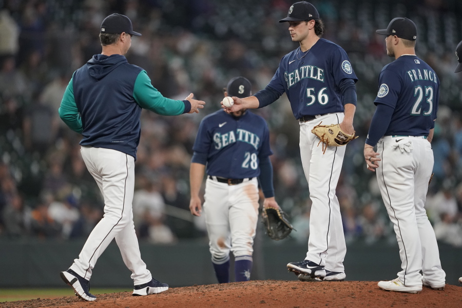Seattle Mariners relief pitcher Penn Murfee (56) is pulled by manager Scott Servais, left, during the eighth inning of the team's baseball game against the Minnesota Twins, Wednesday, June 15, 2022, in Seattle. (AP Photo/Ted S.