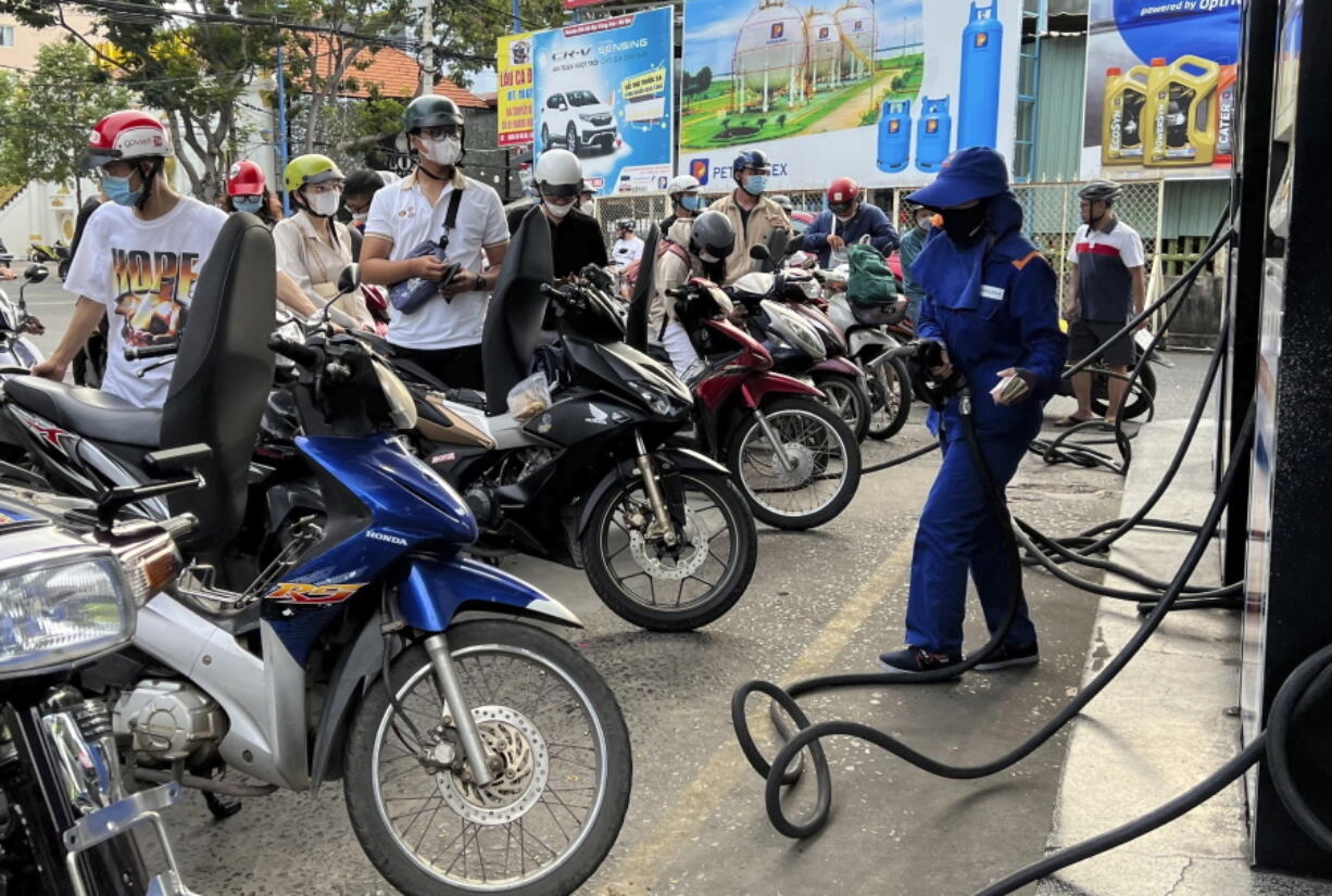 People wait for gas pump in Hanoi, Vietnam Sunday, June 19, 2022. Across the globe, drivers are rethinking their habits and personal finances amid skyrocketing prices for gasoline and diesel, fueled by Russia's war in Ukraine and the global rebound from the COVID-19 pandemic.