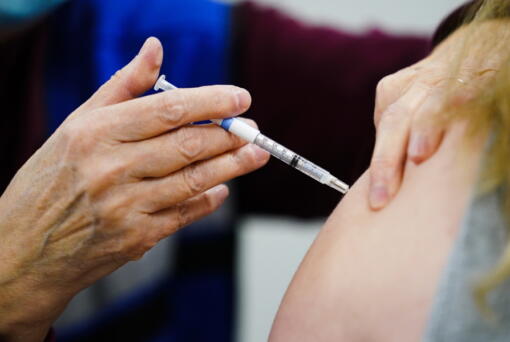FILE - A health worker administers a dose of a COVID-19 vaccine during a vaccination clinic at the Keystone First Wellness Center in Chester, Pa., on Dec. 15, 2021. Government advisers are debating Tuesday, June 28, 2022, if Americans should get a modified COVID-19 booster shot this fall -- one that better matches more recent virus variants.