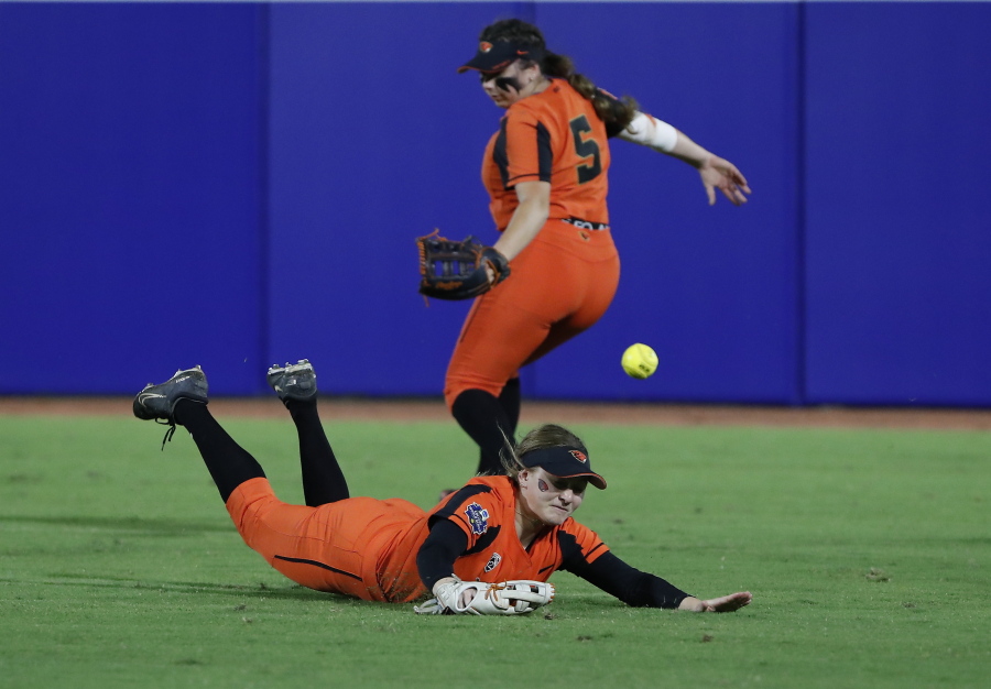 Oregon State outfielders Eliana Gottlieb (12) and Kaylah Nelson (5) miss an Arizona hit to the outfield during the second inning of an NCAA softball Women's College World Series game Friday, June 3, 2022, in Oklahoma City.