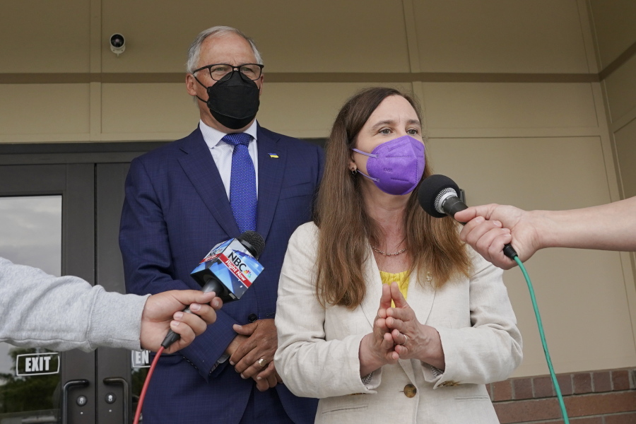 Washington Gov. Jay Inslee, left, wears a mask as he talks to reporters along with Washington State Dept. of Ecology Director Laura Watson, right, Thursday, June 2, 2022, outside a Dept. of Ecology office in Richland, Wash. Inslee, who has recently criticized the slow pace of cleaning up the Hanford Nuclear Reservation in Washington state, was speaking ahead of a scheduled tour of the nuclear weapons production site and repeated his message that more federal money is needed to finish the job. (AP Photo/Ted S.