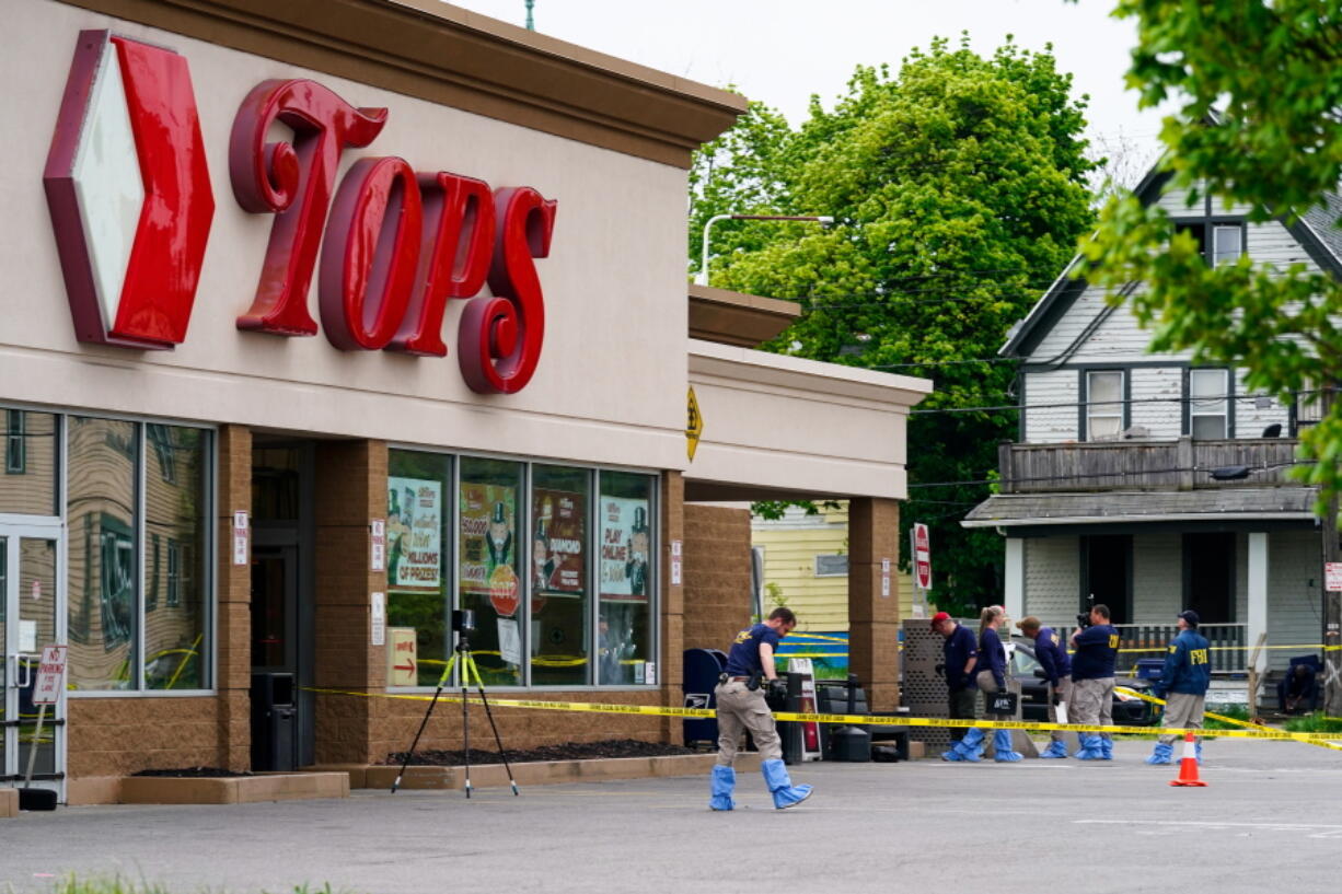FILE - Investigators work the scene after a mass shooting at a supermarket, in Buffalo, N.Y., May 16, 2022. A white 18-year-old entered the supermarket with the goal of killing as many Black patrons as possible and gunned down 10. That shooter claims to have been introduced to neo-Nazi websites and a livestream of the 2019 Christchurch, New Zealand mosque shootings on the anonymous, online messaging board 4Chan.