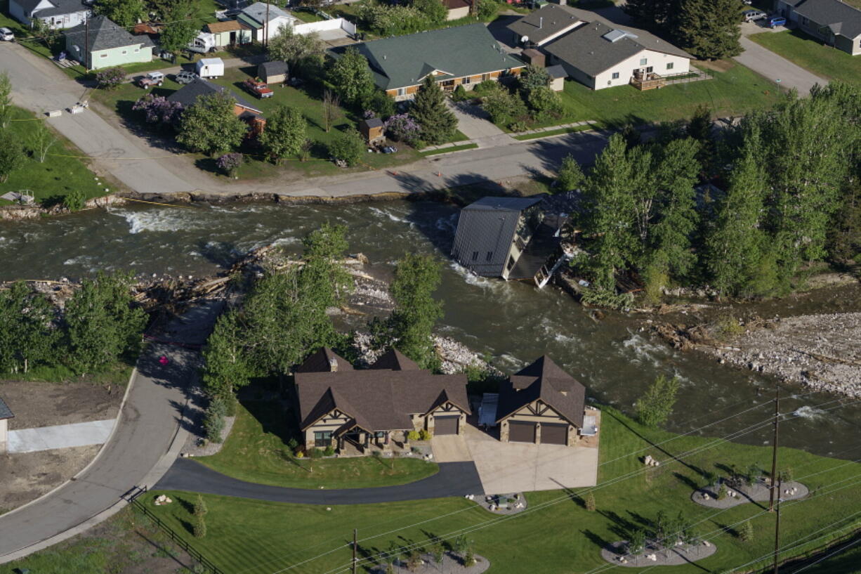 FILE - A house sits in Rock Creek after floodwaters washed away a road and a bridge in Red Lodge, Mont., in Red Lodge, Mont., June 16, 2022.