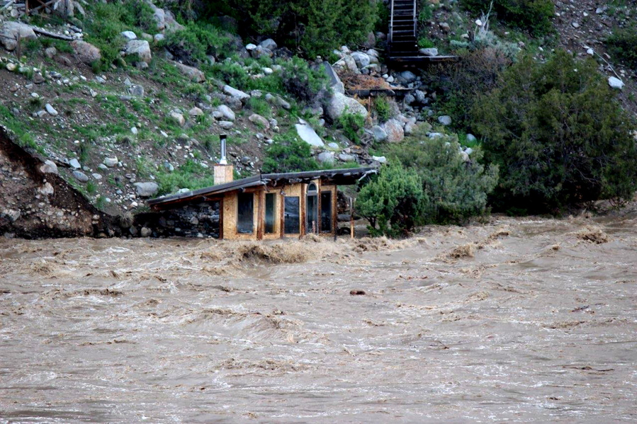 In this photo provided by Sam Glotzbach, the fast-rushing Yellowstone River flooded what appeared to be a small boathouse in Gardiner, Mont., on Monday, June 13, 2022, just north of Yellowstone National Park.
