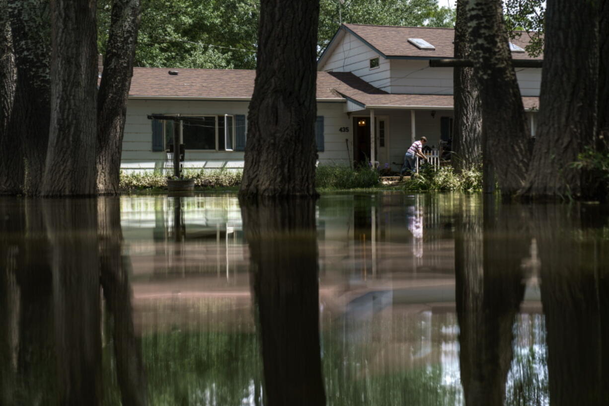 Aileen Rogers helps clean out a friend's house badly damaged by the severe flooding in Fromberg, Mont., Friday, June 17, 2022.