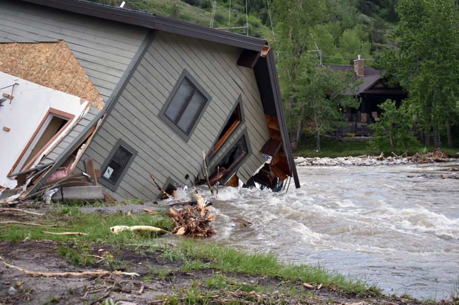 A house that was pulled into Rock Creek in Red Lodge, Mont., by raging floodwaters is seen Tuesday, June 14, 2022. Officials said more than 100 houses in the small city were flooded when torrential rains swelled waterways across the Yellowstone region.