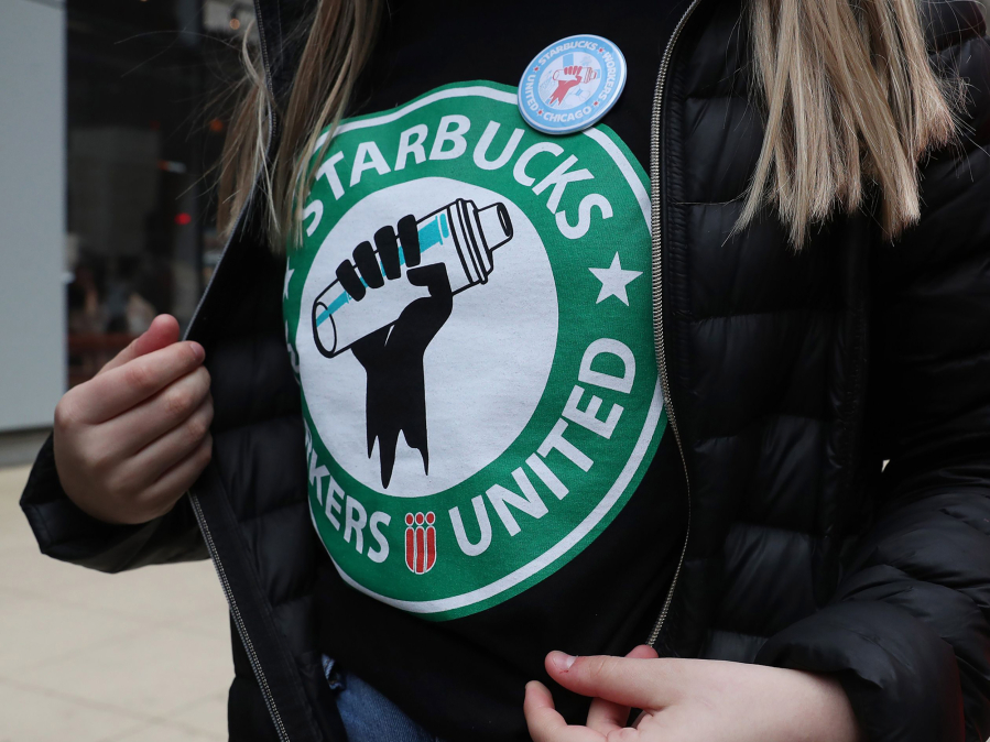 A barista at a Starbucks in Chicago wears a t-shirt and button promoting unionization on April 7, 2022, in Chicago. (John J.