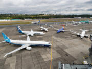 An Icelandair 737 taxis past the 737 MAX family of airplanes outside Boeing???s Seattle Delivery Center at Boeing Field this month. Boeing will require some remote workers to be in the office full time next month to help with ramped up production and supply chain issues ??? and not all of them are ready to come back.