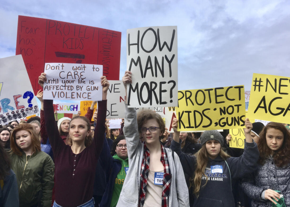 FILE- This March 14, 2018 file photos shows students at Roosevelt High School taking part in a protest against gun violence in Seattle. In the wake of a Valentine's Day shooting that killed 17, a handful of Parkland, Fla., teenagers are on the cusp of pulling off what could be one of the largest marches in history with nearly 1 million expected in DC and more than 800 sister marches planned across every continent.