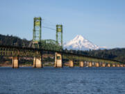 The Hood River Bridge over the Columbia River with Mount Hood in the background is seen from White Salmon.