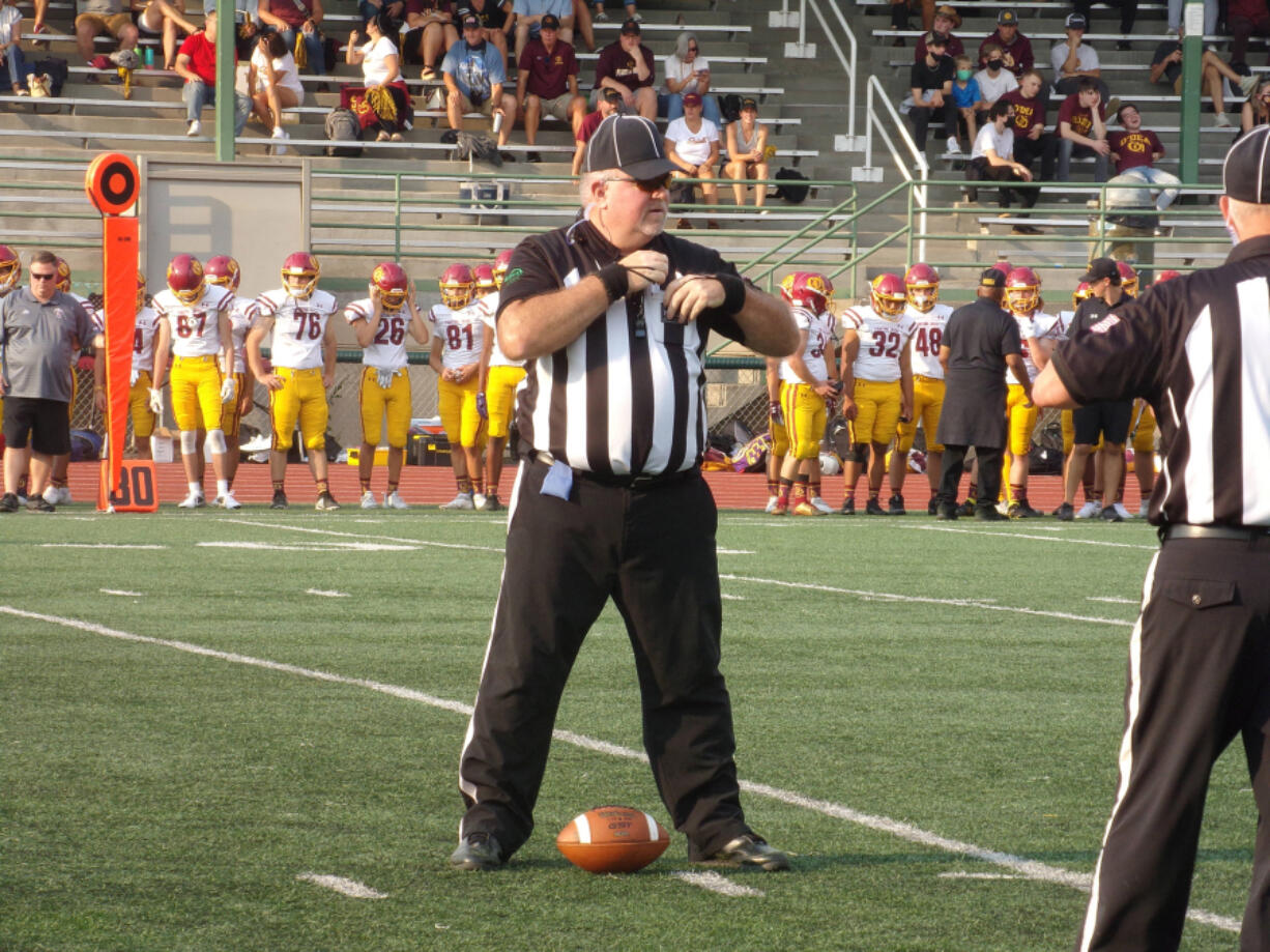 Chris Prothero of the Evergreen Football Officials Association stands over the ball during a timeout at the Union-O'Dea game on Sept. 3, 2021, at McKenzie Stadium.