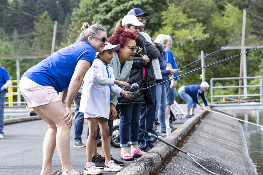 Volunteers, special kids, and parents line up to fish at the Merwin State Fish Hatchery. They were taking part in the Merwin Special Kids Fishing Event, which was held for the first time in two years.