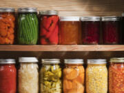 Wooden shelves hold varieties of canned vegetables and fruits.