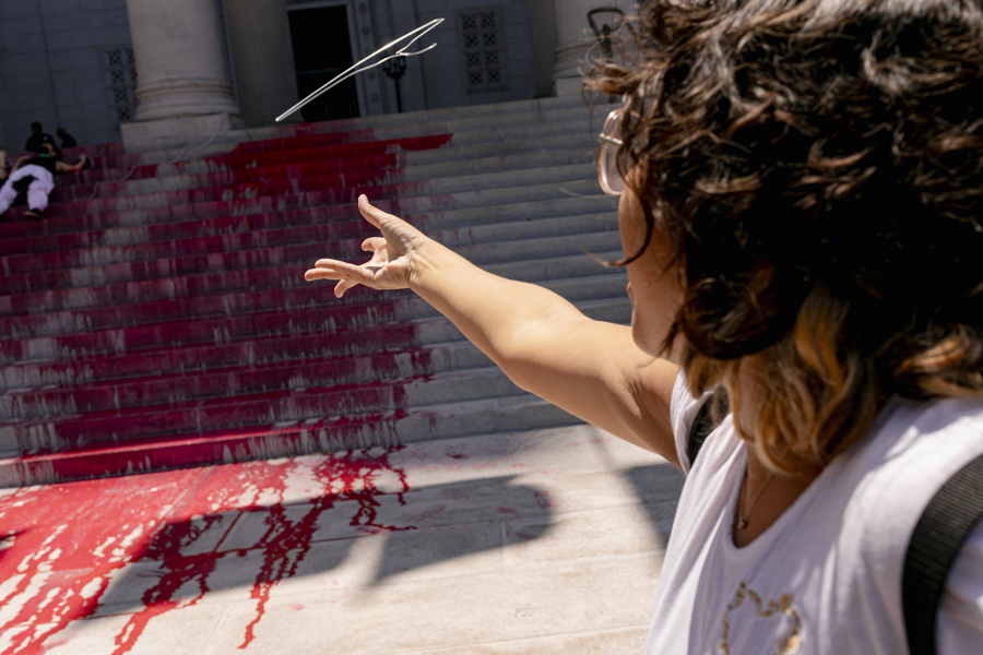 A protester throws a coat hanger representing unsafe abortions outside Los Angeles City Hall.