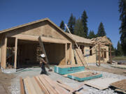 Construction workers lend a hand building homes at the Cedars community in Brush Prairie in July.