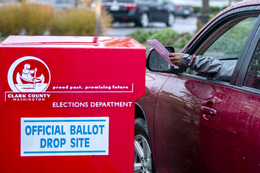 A voter drops off his ballot at a Clark County ballot drop box in the Vancouver Mall parking lot Nov. 3, 2020.
