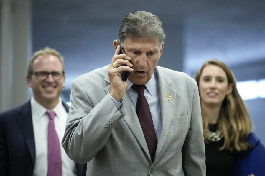 Sen. Joe Manchin (D-WV) talks on the phone as he walks through the Senate subway on his way to a lunch meeting with Senate Democrats at the U.S. Capitol on June 14, 2022, in Washington, D.C.