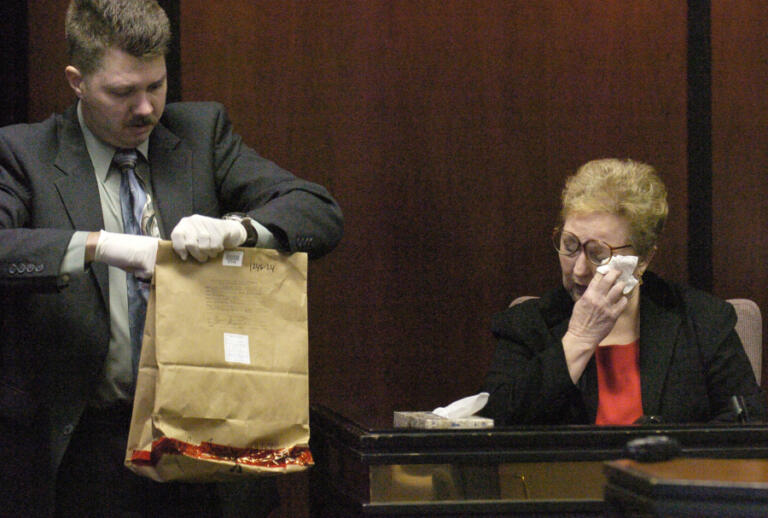 Sylvia Johnson wipes away a tear Jan. 12, 2006, as she is asked to identify evidence items, handled by Scott Smith, a detective with the Vancouver Police Department's Major Crimes Unit.