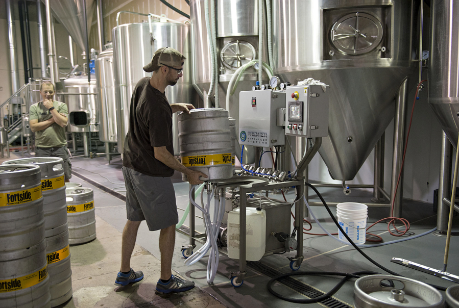 Co-owner Mark Doleski works behind the scenes at Fortside Brewing Company in Vancouver while his partner, Mike DiFabio, looks on. Fortside is joining a lawsuit that aims to make the Oregon beer market easier to access.