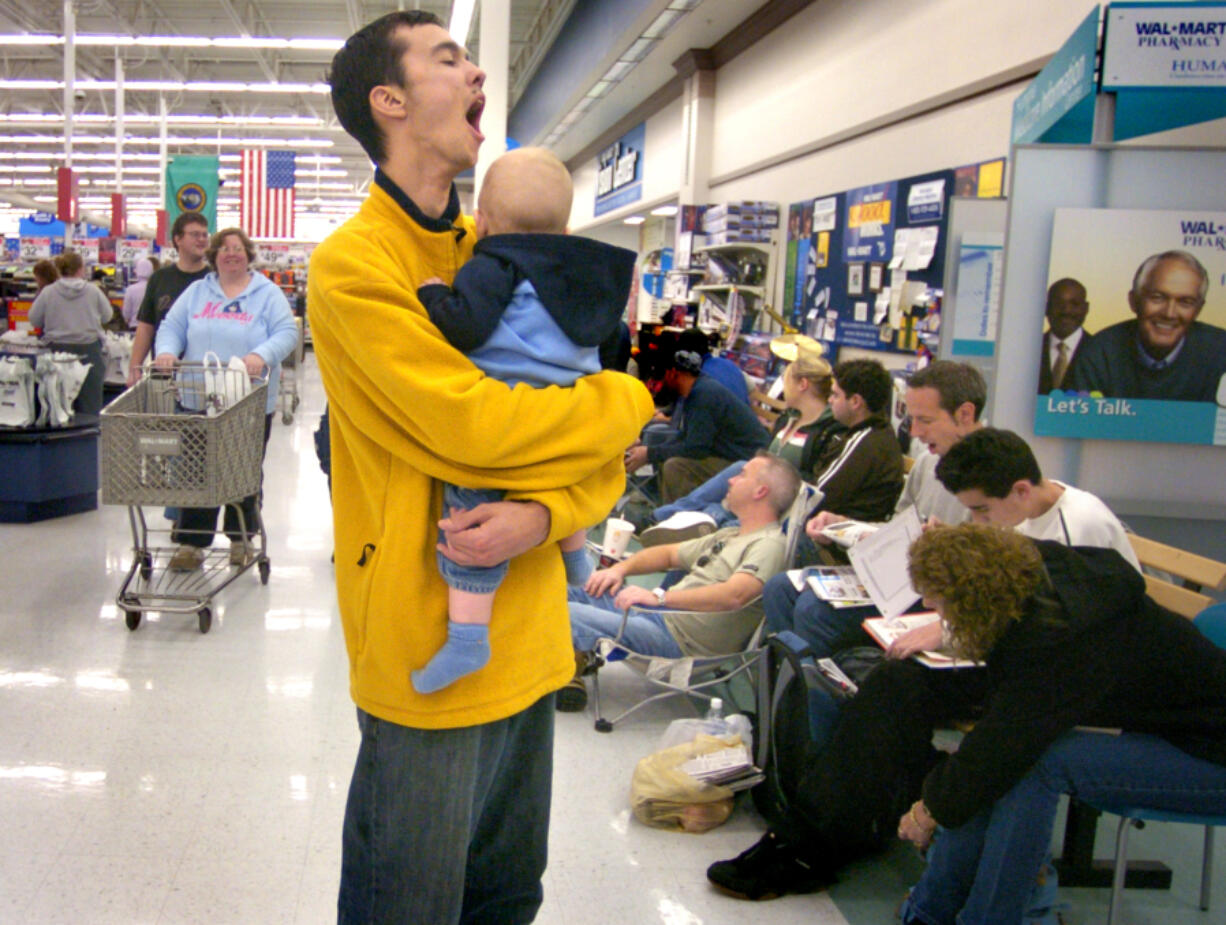 The Columbian files Josh Smith of Battle Ground,  yawns as waits in line to buy an XBox gaming console at a Vancouver Wal-Mart in November 2015.