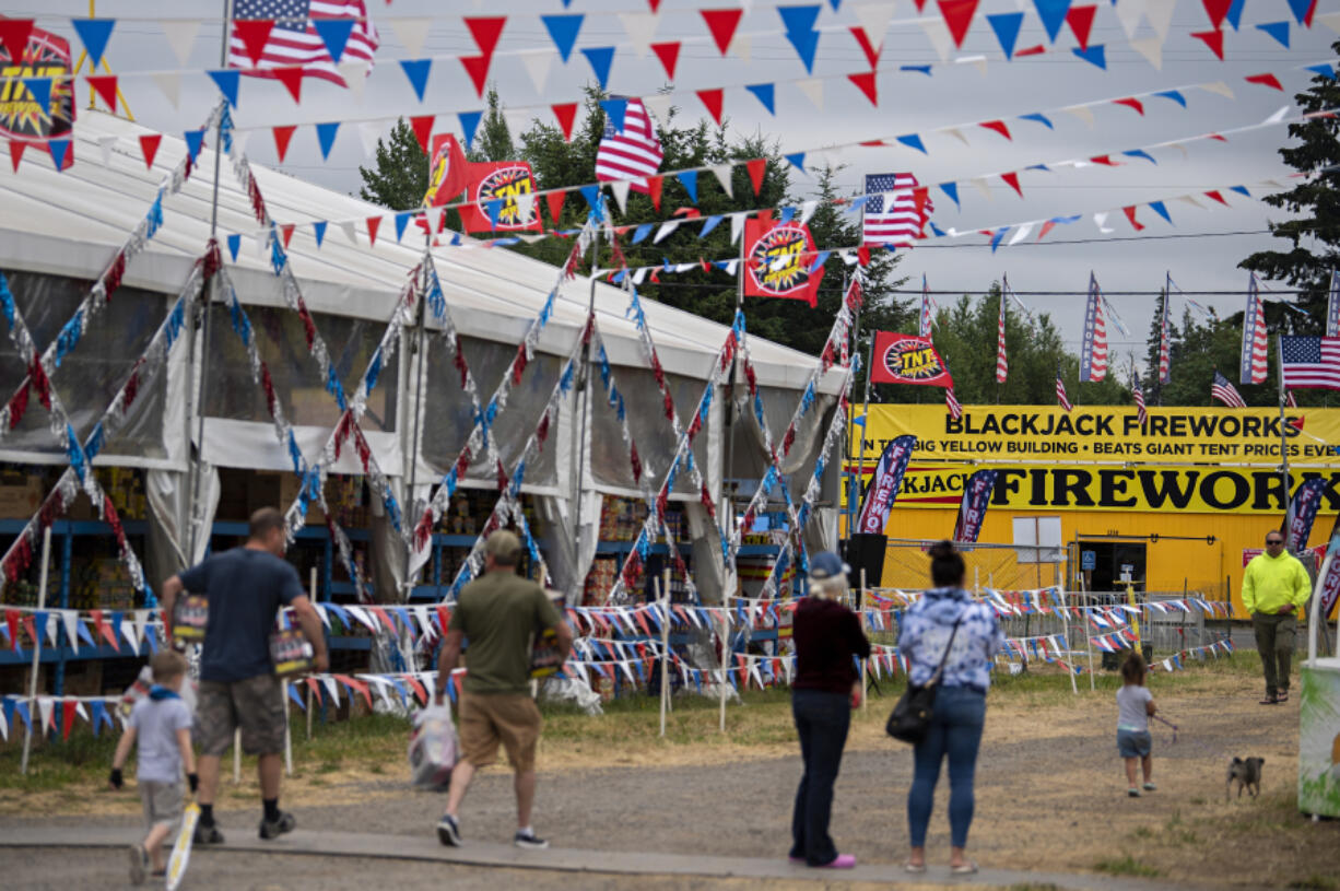 Shoppers visit TNT Fireworks, left, and the nearby Blackjack Fireworks while preparing for their Fourth of July celebrations Friday morning. Fireworks business owners expect crowds to grow larger and larger over the weekend; they'll also be open on Monday.