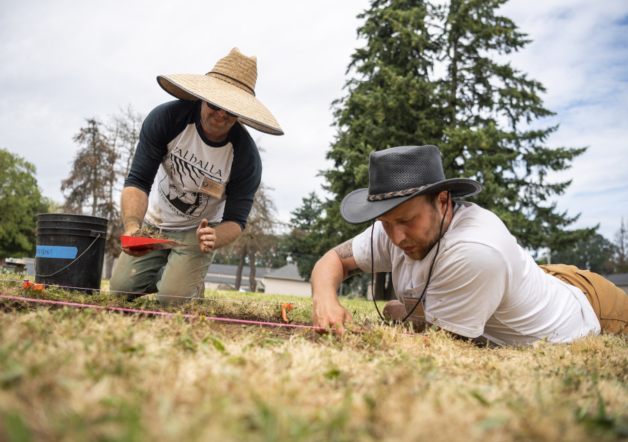 Portland State University student Joshua Haupt, left, scoops dirt into a bucket while Portland State University student Patty Patterson digs in the ground Tuesday during Archaeology Field School at Fort Vancouver National Historic Site.