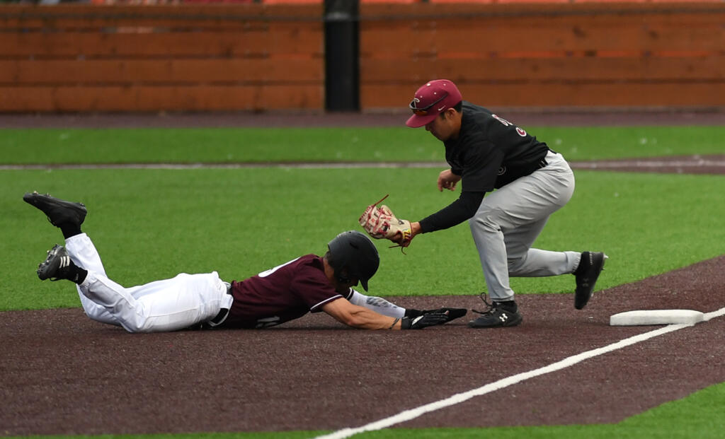 Raptors center fielder Austin Caviness, left, is tagged out sliding into third by Knights third baseman Mason Le on Wednesday, July 6, 2022, during a game between the Ridgefield Raptors and the Corvallis Knights at the Ridgefield Outdoor Recreation Complex.