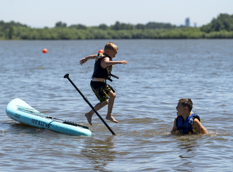 Greyson Gravelle, 5, left, and his brother Keegan Gravelle, 8, cool off on a hot Monday afternoon in Vancouver Lake. With temperatures expected to crack the mid-90s, Vancouver denizens flocked to area rivers and lakes for relief.