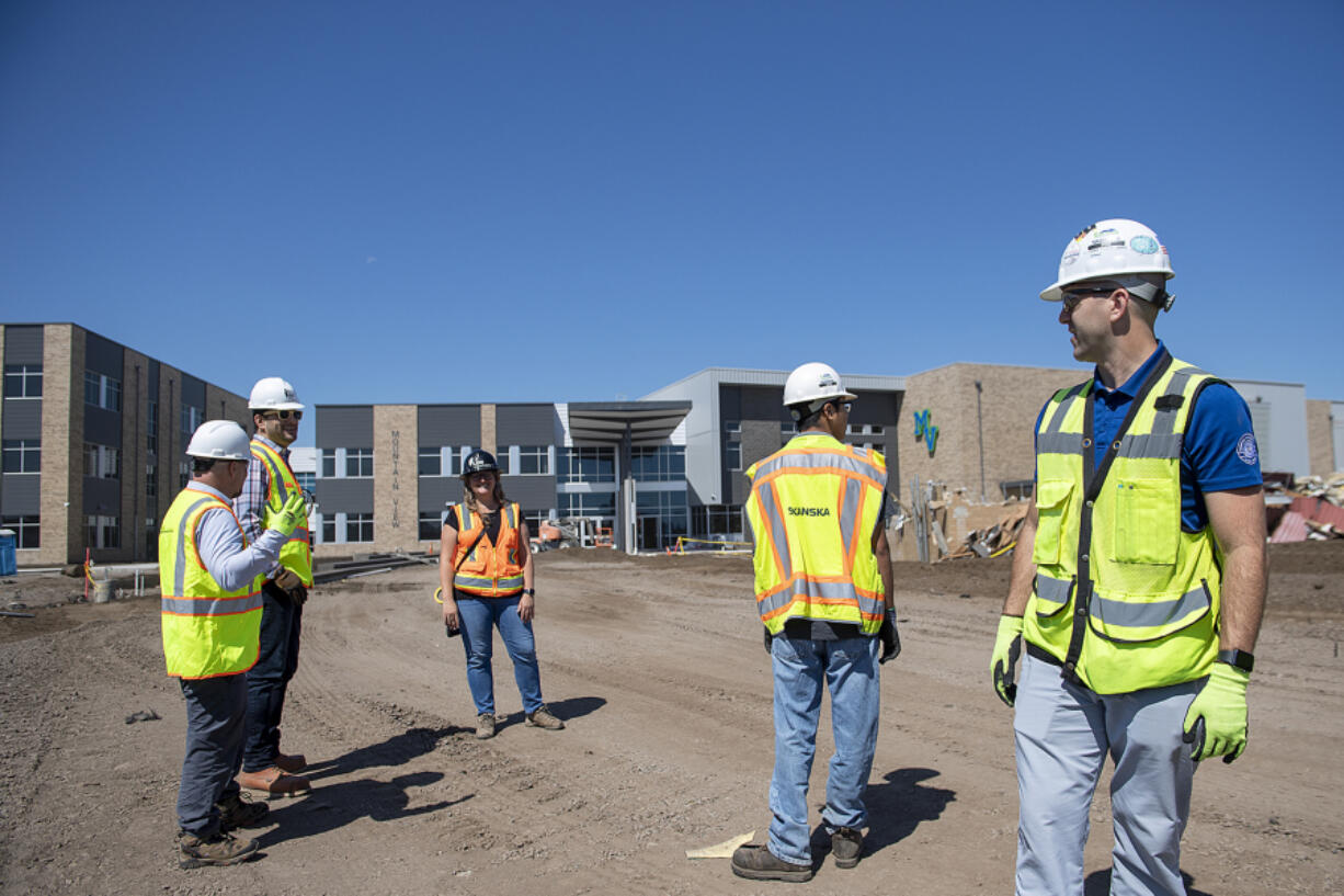 Sean Walker, senior project manager for general contractor Skanska, right, leads a tour of the new Mountain View High School building on Tuesday morning. Evergreen Public Schools is rebuilding the school as part of the last phase of construction initiatives in its 2018 bond measure.