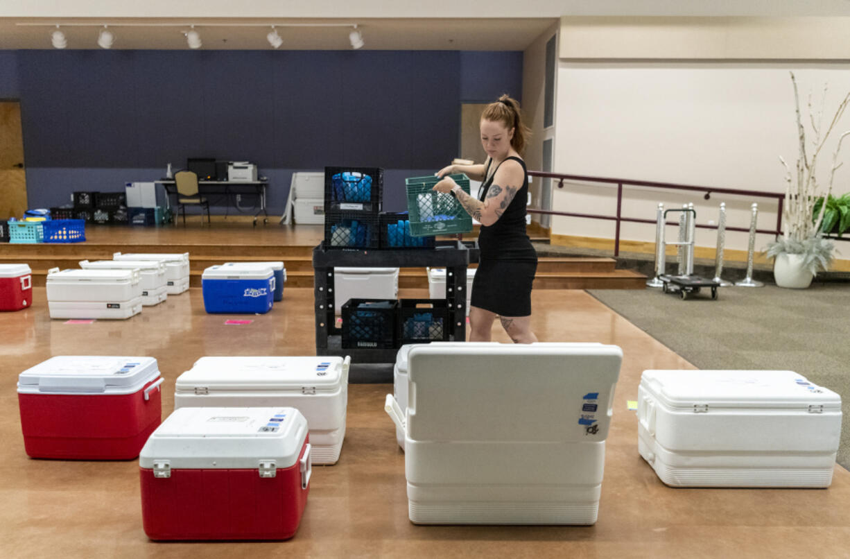 Share kitchen assistant Maddie May loads coolers with ice packs at St. Joseph Catholic Church in Vancouver. The organization is helping low-income students get proper nutrition in the summer.
