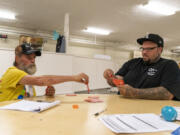 Rob White, left, and Christopher Godwin, an Outsiders Inn employee, play Spades in a cooling center Wednesday at St. Paul Lutheran Church in downtown Vancouver. White is homeless and a senior. He is vulnerable to the elements, and when it gets too hot, he needs shelter to survive. Thankfully, cooling centers are available throughout the city.