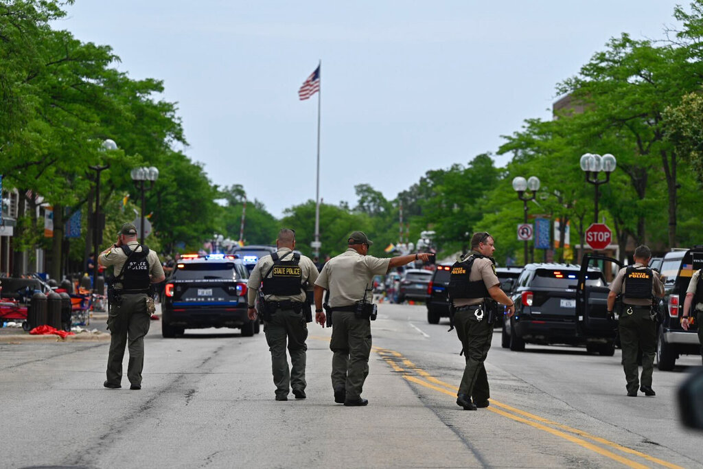 Police search the downtown area of the Chicago suburb of Highland Park, Ill., after a mass shooting at a Fourth of July parade Monday, July 4, 2022.