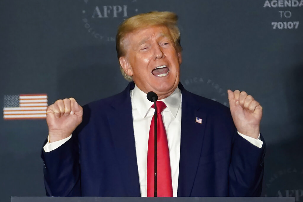 Former President Donald Trump talks about lifting weights as he speaks at an America First Policy Institute agenda summit at the Marriott Marquis in Washington, Tuesday, July 26, 2022.