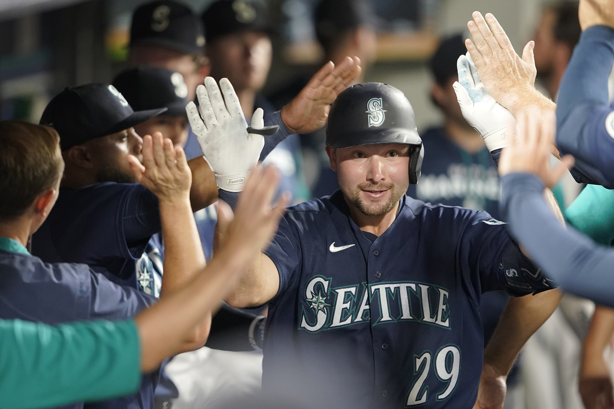 Seattle Mariners' Cal Raleigh is greeted in the dugout after he hit a solo home run against the Texas Rangers during the seventh inning of a baseball game, Tuesday, July 26, 2022, in Seattle. (AP Photo/Ted S.