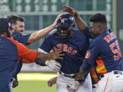 Houston Astros' Yordan Alvarez, center, celebrates with teammates after hitting a game-winning RBI-single against the Seattle Mariners during the 10th inning of a baseball game Sunday, July 31, 2022, in Houston. The Astros won 3-2 in 10 innings. (AP Photo/David J.