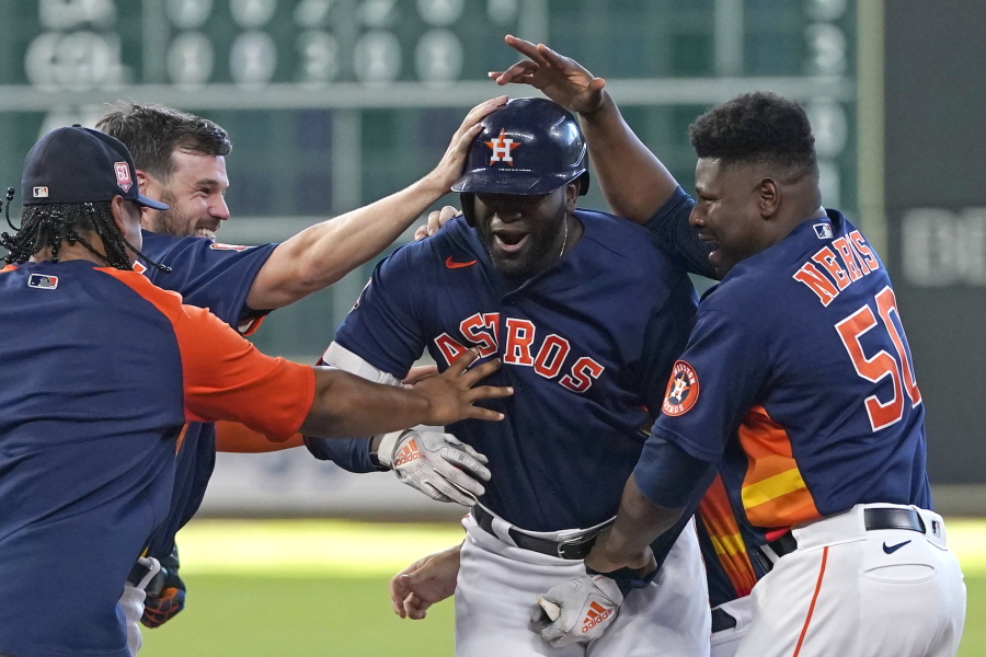 Houston Astros' Yordan Alvarez, center, celebrates with teammates after hitting a game-winning RBI-single against the Seattle Mariners during the 10th inning of a baseball game Sunday, July 31, 2022, in Houston. The Astros won 3-2 in 10 innings. (AP Photo/David J.