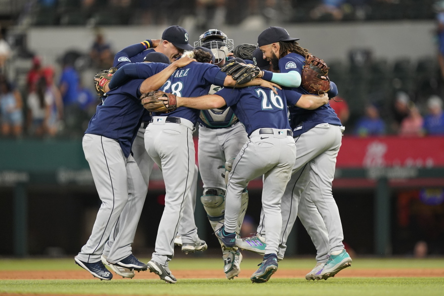 The Seattle Mariners dance in a circle after the final out of the baseball game against the Texas Rangers in Arlington, Texas, Sunday, July 17, 2022. The Mariners won 6-2.