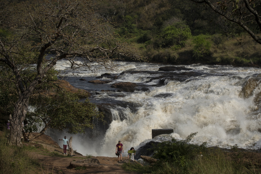 Tourists walk at the top of the waterfalls in Murchison Falls National Park, northwest Uganda, on Feb. 22, 2020. The East Africa Crude Oil Pipeline, a controversial oil project that would connect oilfields in the park to a port in Tanzania is in breach of global environmental and human rights guidelines for banks, according to a new report by Inclusive Development International on Tuesday, July 5.
