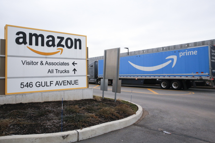 FILE - An Amazon Prime truck passes by a sign outside an Amazon fulfillment center on Staten Island, New York, on March 19, 2020. Amazon is heading into its annual Prime Day sales event on Tuesday, July 12, 2022, much differently than how it entered the pandemic. Once the darling of the pandemic economy, the company posted a rare quarterly loss in April as well as its slowest rate of revenue growth in nearly two decades at 7%.
